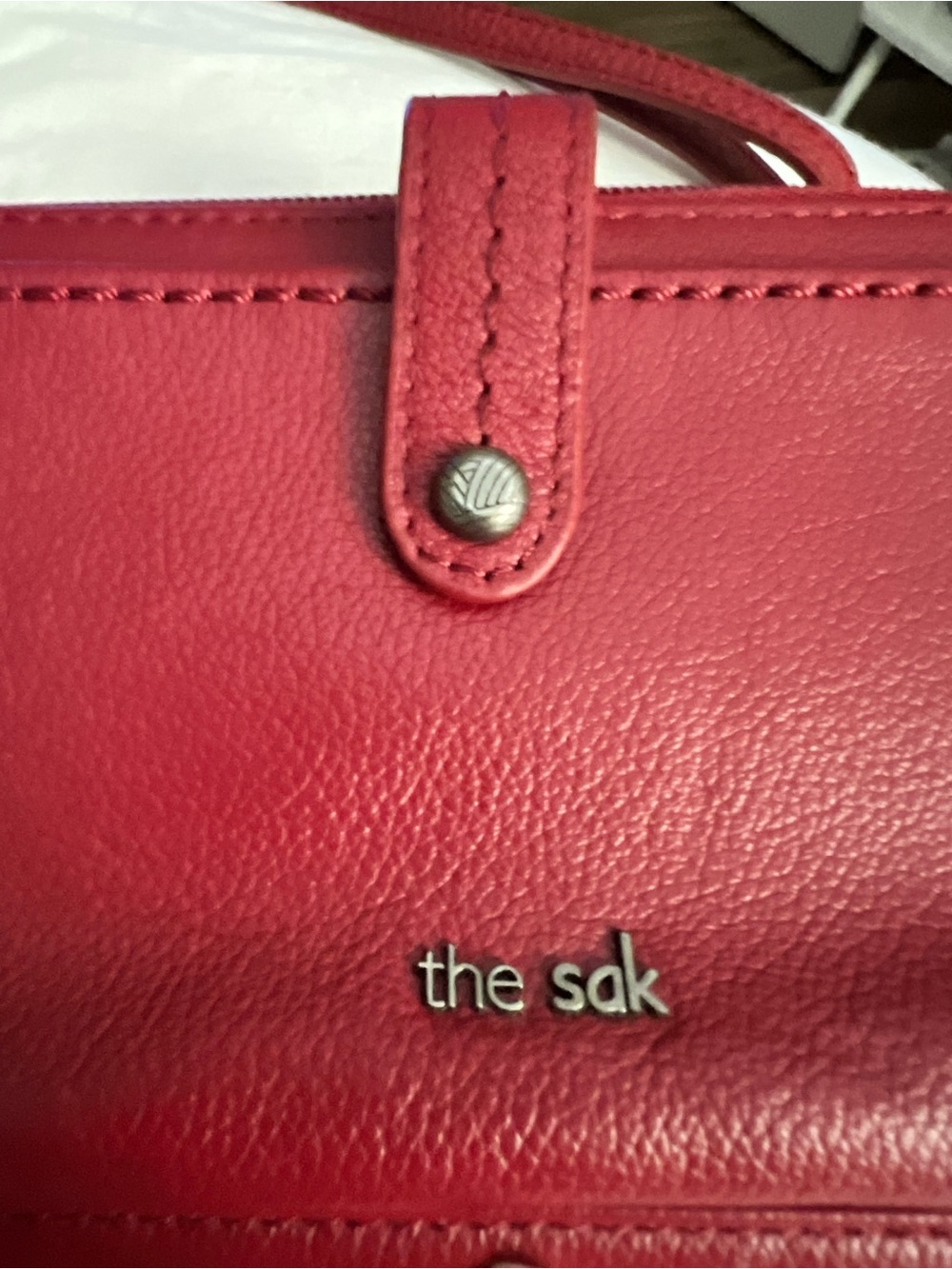 The Sak Red Pebbled Leather Shoulder Bag with Silver Logo/smartphone pocket.
